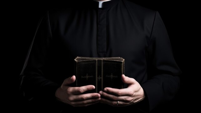 Catholic priest in black robe holds Holy Bible standing in old rural church closeup