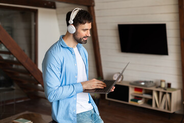 Aufkleber - Man Using Laptop Computer With Headphones at Home Interior