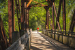 View from inside of railroad bridge  converted into recreational trail in summer; male bicyclist riding   in background