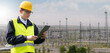 Worker with digital tablet on a background of power station.