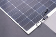 Thin flexible mobile solar panel with cable for connection.