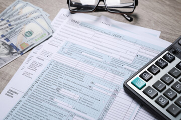 Wall Mural - Payroll. Tax return forms, dollar banknotes and calculator on wooden table