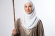 A young woman wearing a hijab and holding a staff