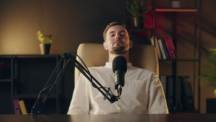 Positive caucasian podcaster wavings hand during saying hello to subscribers. Blogger recording podcast program in social networks. Famous influencer talking microphone at professional studio