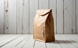© Giedrius - A brown paper bag sits on a white color wooden table