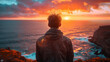 © ART IS AN EXPLOSION. - A man stands on a cliff overlooking the ocean, watching the sun set