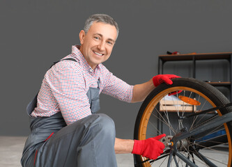 Sticker - Mature mechanic repairing bicycle wheel in workshop