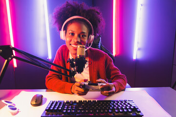 Wall Mural - Host channel of gaming streamer, African girl playing online game with joystick, talking with viewers media online on microphone. Esport skilled team players in neon color lighting room. Tastemaker.