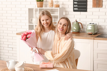 Wall Mural - Cute little girl giving bouquet her mom for Mother's Day at home