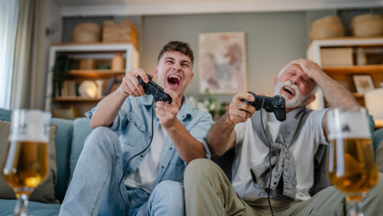 Wall Mural - teenager male and his grandfather senior man play console video game