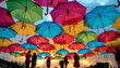 © Train arrival - Wide-angle rainy street view with hinged multicolored umbrellas protecting passersby from the raindrops. Beautiful art installation.