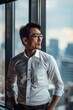 Handsome 45 years old gentle Korean man, wearing glasses, formal slick hairstyle, smooth beardless face in a modern office building, wearing white shirt, beside a huge window
