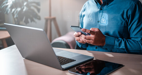 Wall Mural - marketing, social, network, person, media, message, connection, communication, security, global. A man is sitting at a desk with a laptop and a smartphone. around that health.