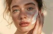 Young beautiful model girl applying sunscreen creme on facial skin. Natural Beauty. Cosmetics for summer with SPF protection. Organic cosmetic product