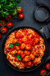 Italian spaghetti in bolognese sauce with meatballs, black table background, top view