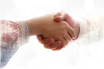 Wall Mural - Double exposure of cityscape and partners shaking hands on white background, closeup