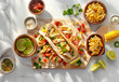 A wooden board with chicken tacos, lime slices and corn