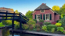 Traditional Dutch Houses, Gardens And Water Canals And Wooden Bridges In Village Is Know As Venice Of The North. Giethoorn, Netherlands, Julay 30, 2023. High Quality 4k Footage