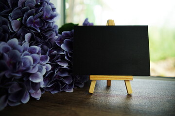 Canvas Print - Empty card space for text message with wooden easel and flower bouquet on wooden background