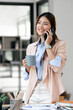 Smiling businesswoman using her phone in the office.