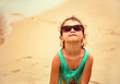 Fun happy kid girl playing outdoor in sunglasses on summer beach holiday sea background. Closeup