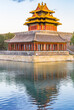 Corner tower reflected in the moat of the Forbidden City in Beijing, China
