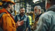 © sambath - A focused shot of factory workers and engineers gathered in a workshop, engaged in discussion about work projects, showcasing collaboration and teamwork in industrial settings.