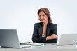 Mid aged businesswoman sitting at desk and using laptops