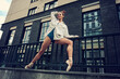 ballerina poses on a street staircase while walking around the city