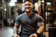 Young muscular man in wheelchair looks at camera and smiles. Disability and fitness concept. Fit bodybuilder sit down on a wheel chair smile and enjoy workout leisure activity alone