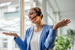 © Westend61 - Mature businesswoman talking through headset gesturing in office