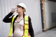Portrait Happy caucasian logistic engineer pregnant woman working and drinking water at container site	