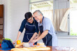 Senior Asian father and middle-aged son cooking together in kitchen, Happiness Asia family concepts