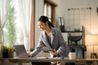 © Thitisak - ฺAsia Businesswoman sitting and working using laptop to chat with customers online in office