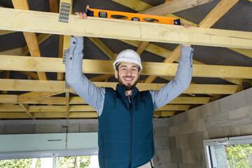 happy male construction worker adjusting ceiling