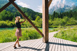 Travel, Freedom, Lifestyle concept. Young woman enjoying green nature outdoors. Amazing view on Zelenci (into English means - green) natural reserve in Slovenia, Europe. People in nature background.