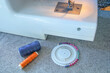 A sewing machine with a spool of thread and a pin needle on a table