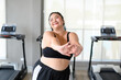 Happy Overweight Asian woman stretching before some main exercises in gym. Weight loss workout, healthy lifestyle concept.