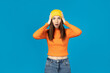 Surprised girl in hat on blue background