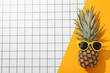 Sunglasses on pineapple on light background, space for text