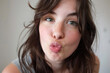 An attractive young woman blowing a kiss.