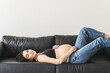Pregnant woman on black couch