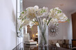 A bouquet of white orchids in the interior. Artificial flowers in a vase. A vase with beautiful orchid flowers on the dresser in the living room.