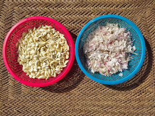 Peeled Garlic Cloves. Fresh cloves of garlic background. Cleaned Garlic in red basket. A strong-smelling pungent-tasting garlic, used as a flavoring in cooking and in herbal medicine. Top (above) view