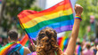 A woman's raised fist with rainbow flag during pride parade