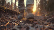 Close up of man's feet in hiking boots walking on forest path at sunrise