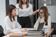 © SOMKID - Group of young asian businesswoman working and brainstorming in workshop and analyzing marketing reports startup project infographics in the office.