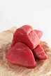 Tuna slices for steak. Fresh tuna. Pieces of fish are lying on craft paper. White background.