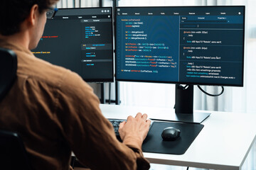 it developer working online software development on pc monitors at modern home office on coding appl