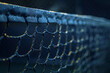 Detailed shot of a blue sports net edge with water droplets on it against a dark blurred background